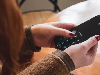 Woman entering passcode on mobile phone